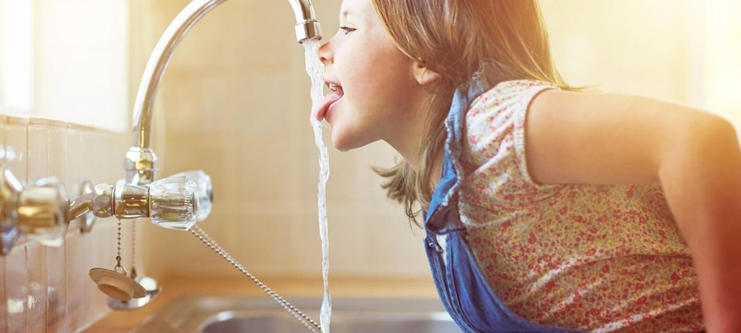 Trinkwasser: Ein Mädchen trinkt vom Wasserhahn