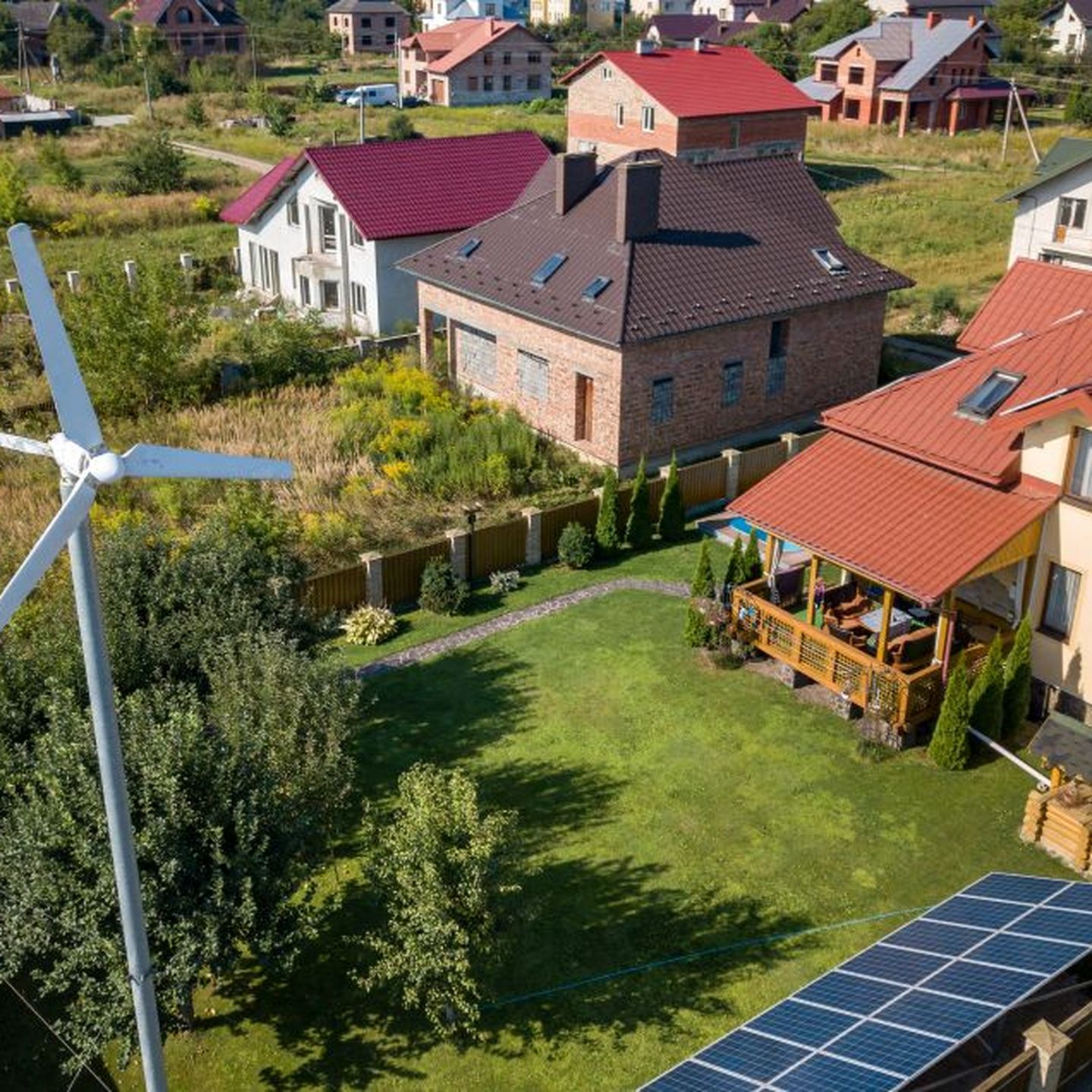Luftaufnahme eines Hauses mit Windkraftanlage im Garten © Bilanol / iStock via Getty Images
