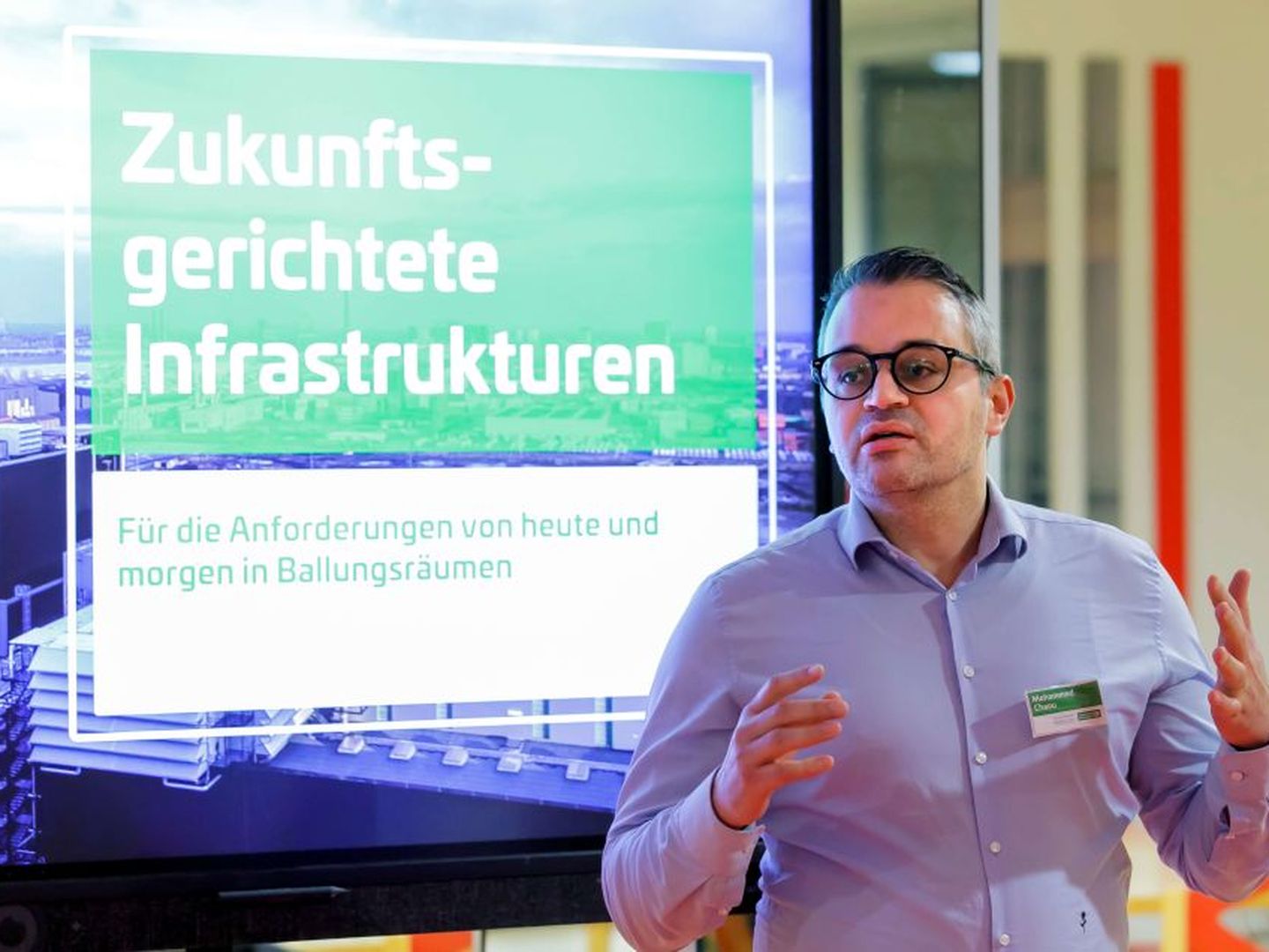 Referent spricht vor einem Bildschirm mit der Aufschrift „Zukunftsgerichtete Infrastrukturen“. © Stadtwerke Düsseldorf © Stadtwerke Düsseldorf