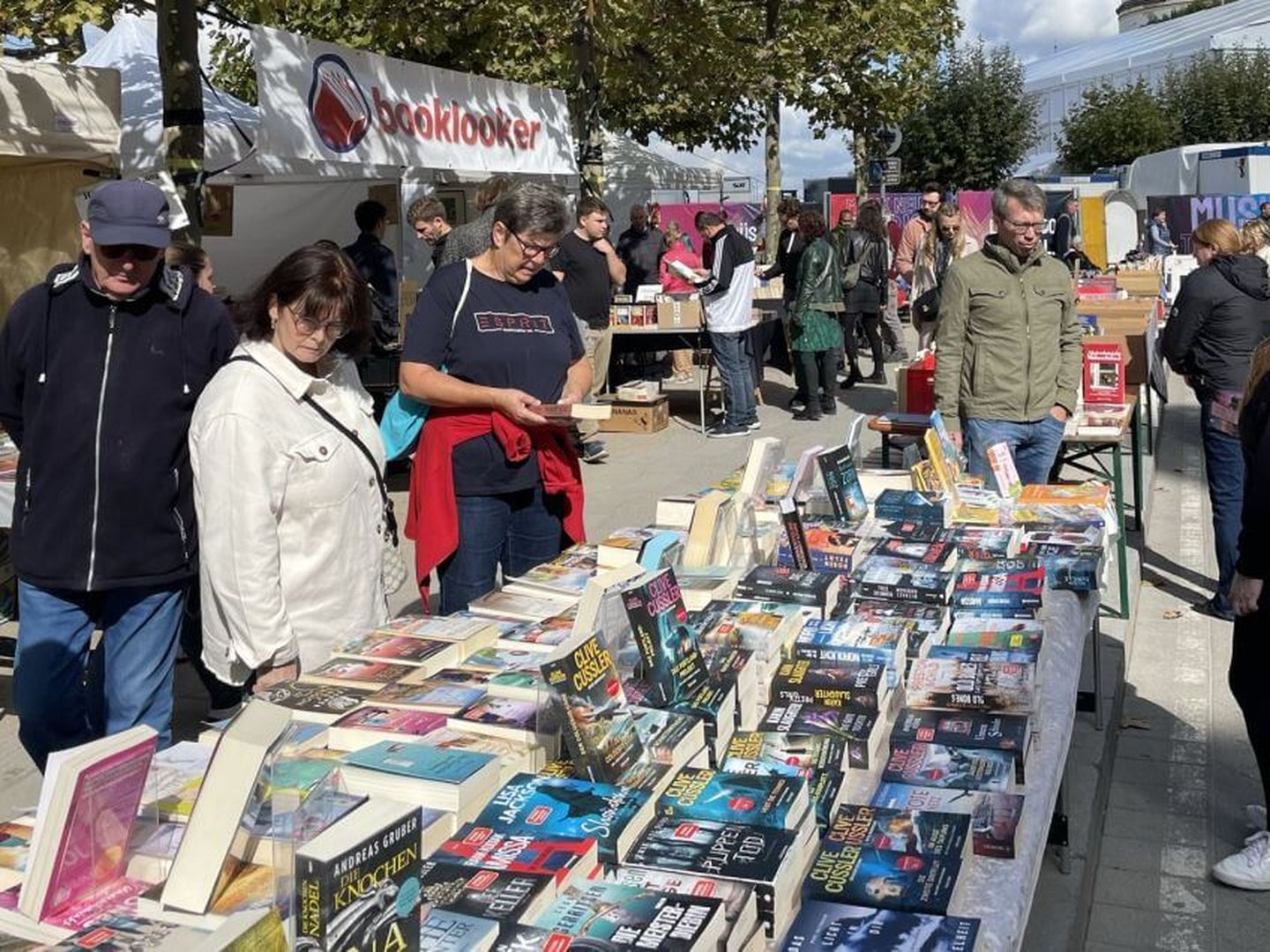 Menschen schlendern auf der Büchermeile in Düsseldorf und betrachten Bücher. Claudia Adams / Altstadt Marketing GmbH